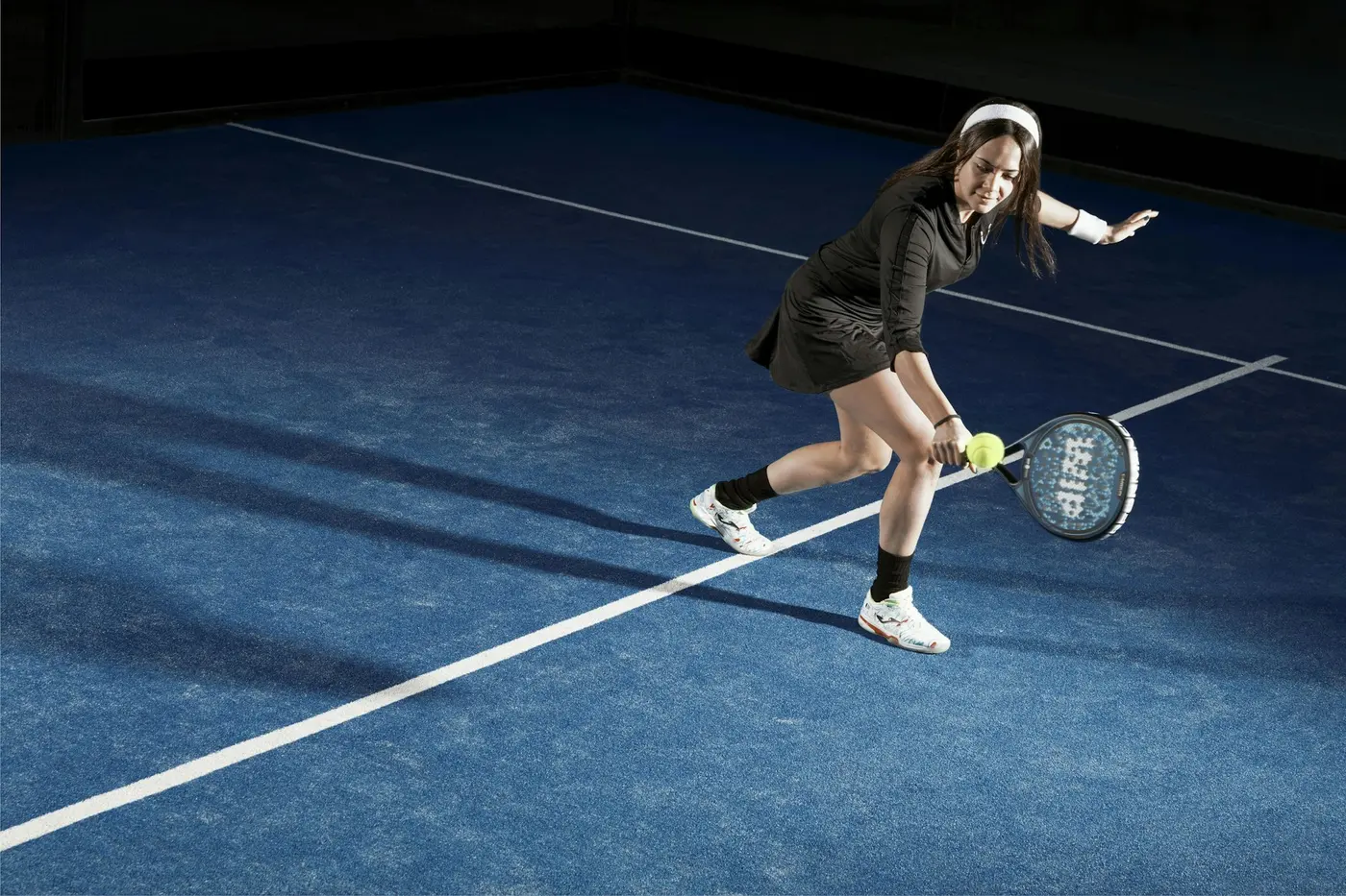 Giocatrice di padel che colpisce di rovescio