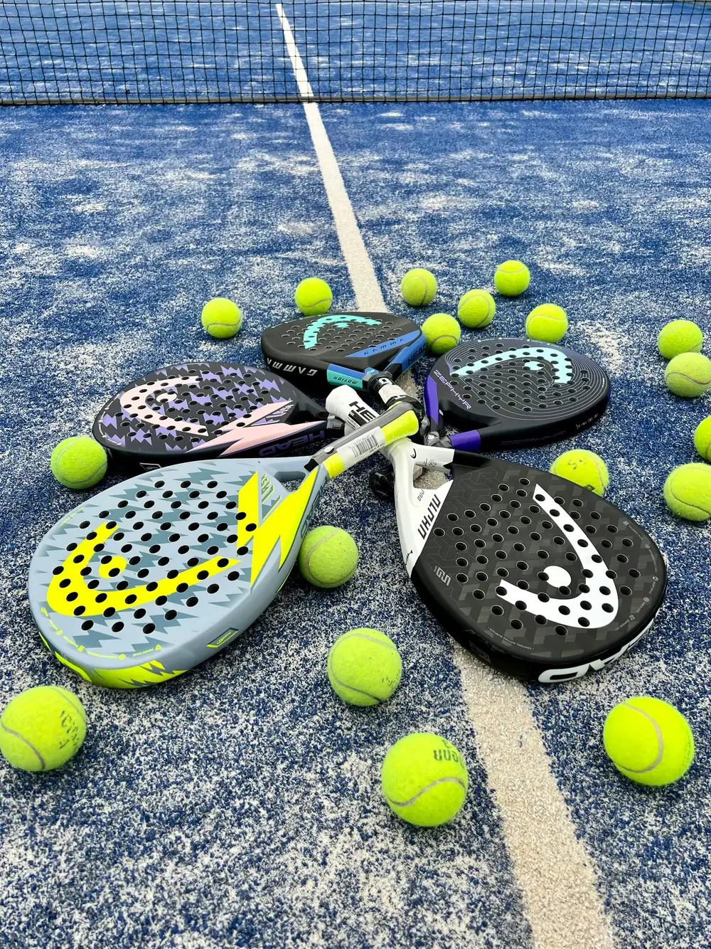 Racchette e palline da padel Racchette da padel e palline gialle sul campo blu